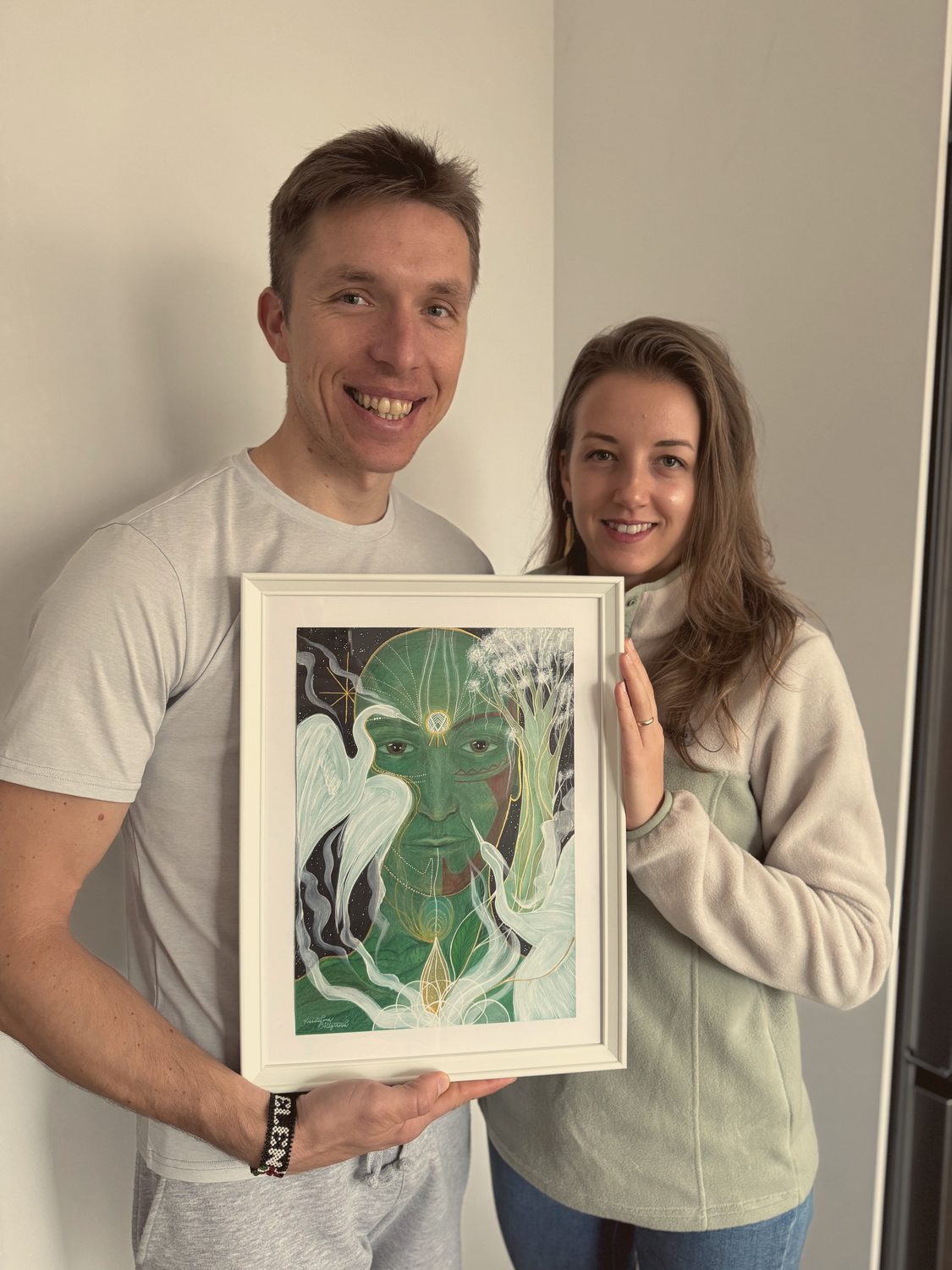 Pár drží hotový intuitivní obraz v zelených tónech